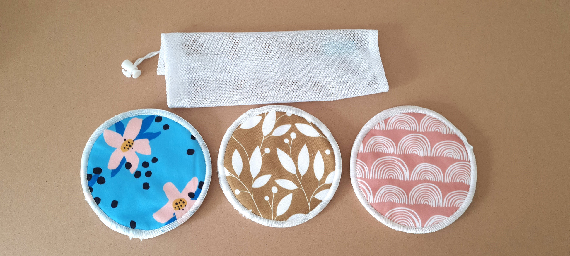 Image. Breast pads for nursing mothers. Set of 3  multi coloured design. 3 layers outer PUL, middle absorbent micro fibre, inner soft terry bamboo. 12.5 cm diameter. Come with mesh laundry bag.