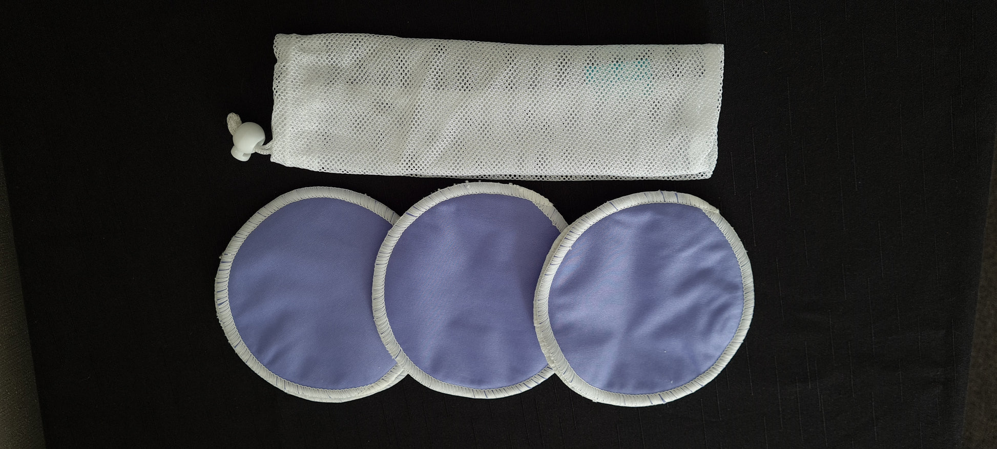 Image. Breast pads for nursing mothers. Set of 3  mauve design. 3 layers outer PUL, middle absorbent micro fibre, inner soft terry bamboo. 12.5 cm diameter. Come with mesh laundry bag.