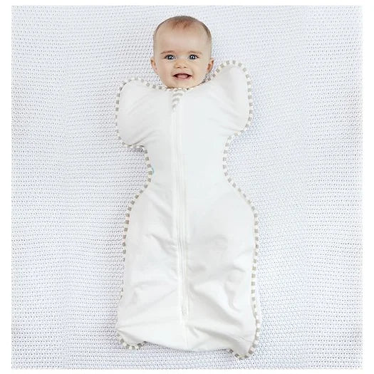 Image. Swaddle Up sleep suit for baby. Made with Organic Cotton fabric. Cream with beige and cream striped border. Love to Dream's Swaddle Up™ supports the natural sleep position of babies who like to have their Arms Up™ – enabling true Self-Soothing™, while still calming the startle reflex with the garment's snug, swaddle fit.